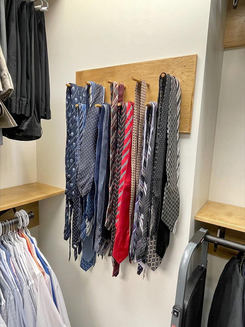 A wall-mounted rack of various neckties